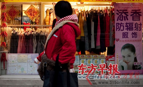 12月19日,長樂路一家主打防輻射服的孕婦服裝店,一位準媽媽在向店內張望。早報記者 孫湛 圖